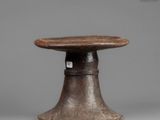 an old wooden stool with a wooden top and a metal base