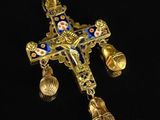 a close up of a cross with bells on a black surface