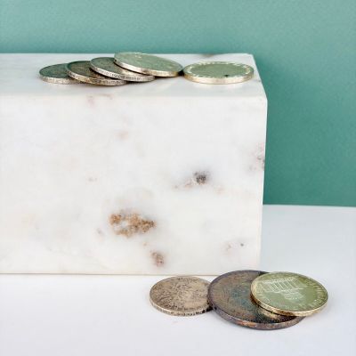 un bloc de marbre sur lequel sont posées des pièces de monnaie