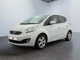 the small white car is parked in a large room