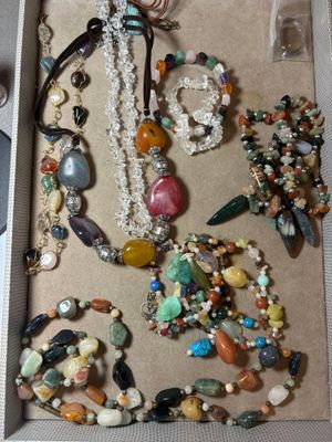 une boîte remplie de bijoux variés et une paire de ciseaux