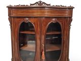 une vieille armoire en bois avec deux portes vitrées et une étagère