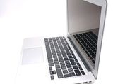 a white laptop with a black keyboard on a white surface
