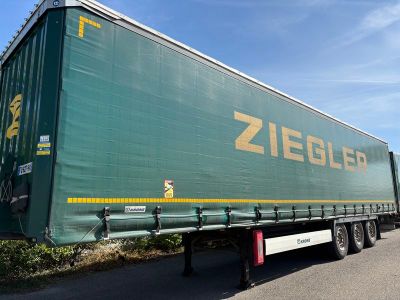une semi-remorque verte garée sur le bord de la route