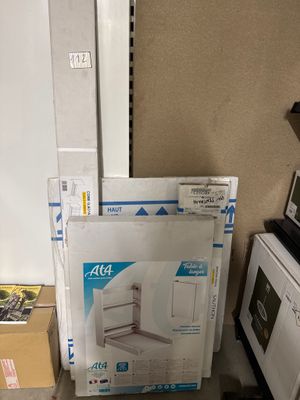 une pile de cartons posée par terre à côté d'un micro-ondes