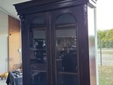 a black china cabinet in the middle of a room