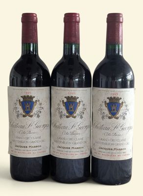 three bottles of red wine sitting on top of a white table