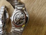 two watches that are sitting on a wooden table