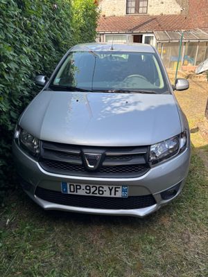 l'avant d'une voiture argentée garée devant une haie