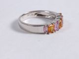 a close up of a white gold ring with pink and orange stones