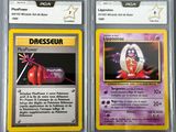 two pokemon cards are shown in plastic cases on a table