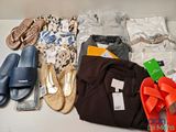 de nombreuses paires de chaussures et de vêtements disposés sur une table
