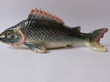 une figurine de poisson posée sur une surface blanche