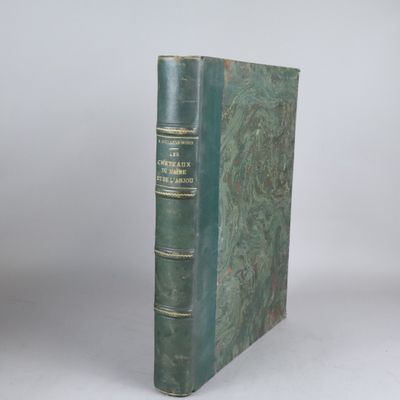 un vieux livre à la couverture verte posé sur une table