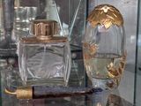 une vitrine en verre sur laquelle sont posés des flacons de parfum et un rasoir