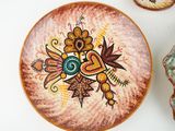 a plate with a flower design on it next to other dishes