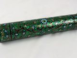 un tube vert orné de fleurs bleues sur un fond blanc