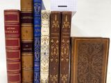 plusieurs vieux livres sont alignés sur une surface blanche