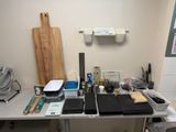 un bureau sur lequel se trouvent un ordinateur portable, une planche à découper et d'autres ustensiles de cuisine