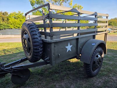 un vieux camion militaire avec un gros pneu à l'arrière