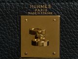 the handle of a black purse with gold hardware on it