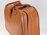 brown leather suitcase on a white surface with a white background