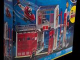 a box of playmobil action heroes with a fire station