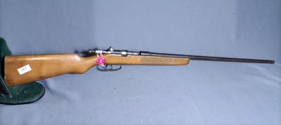 the rifle is laying on the table with a hat on it