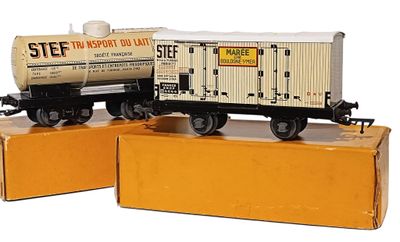 deux petits trains posés sur des cartons, sur une surface blanche