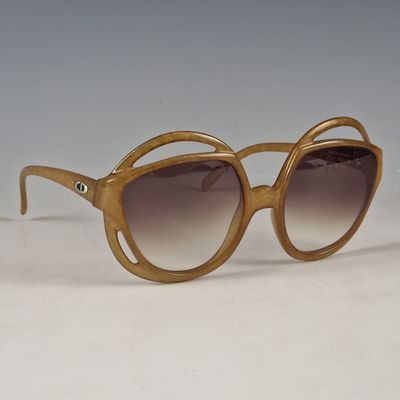 des lunettes de soleil marron posées sur une surface blanche