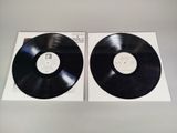 two black vinyl records sitting on top of a white box