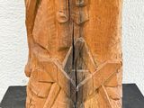 carved wooden sculpture of a man and a woman holding hands