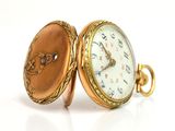 an image of a close up of a pocket watch on a white surface