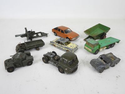 Plusieurs petites voitures et camions sont alignés sur une surface blanche