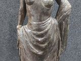 bronze statue of a woman with a dress and a hat