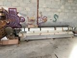 un graffiti sur le mur d'un immeuble, avec un tas de tuyaux métalliques