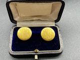 an image of a pair of gold cufflinks in a case
