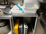 une petite cuisine équipée d'une cuisinière, d'un évier et d'autres appareils électroménagers