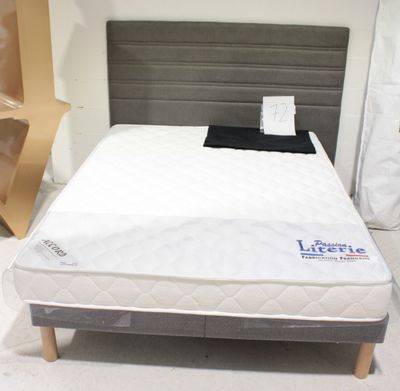 un lit sur lequel est posé un matelas dans une pièce