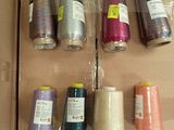 many spools of thread in a box on the floor