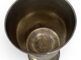 a metal cup that is sitting on top of a table