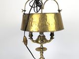 une lampe ancienne en laiton avec un abat-jour en laiton sur fond blanc