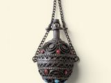 a close up of a metal lantern hanging from a chain