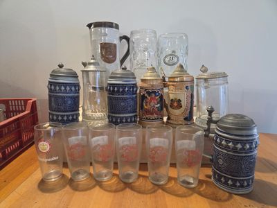 a lot of beer glasses and a pitcher on a table