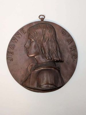 une vieille médaille en bronze sur laquelle est représenté le visage d'un homme