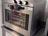 a stainless steel oven sitting on a table in a kitchen