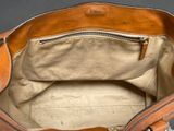 a brown bag with a zipper on it sitting on a table