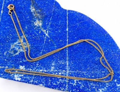 necklace on a blue marble slab with a gold chain