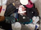 un tas de vêtements et de chapeaux posés dans un bac