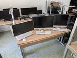 three computer monitors sitting on a desk in a room